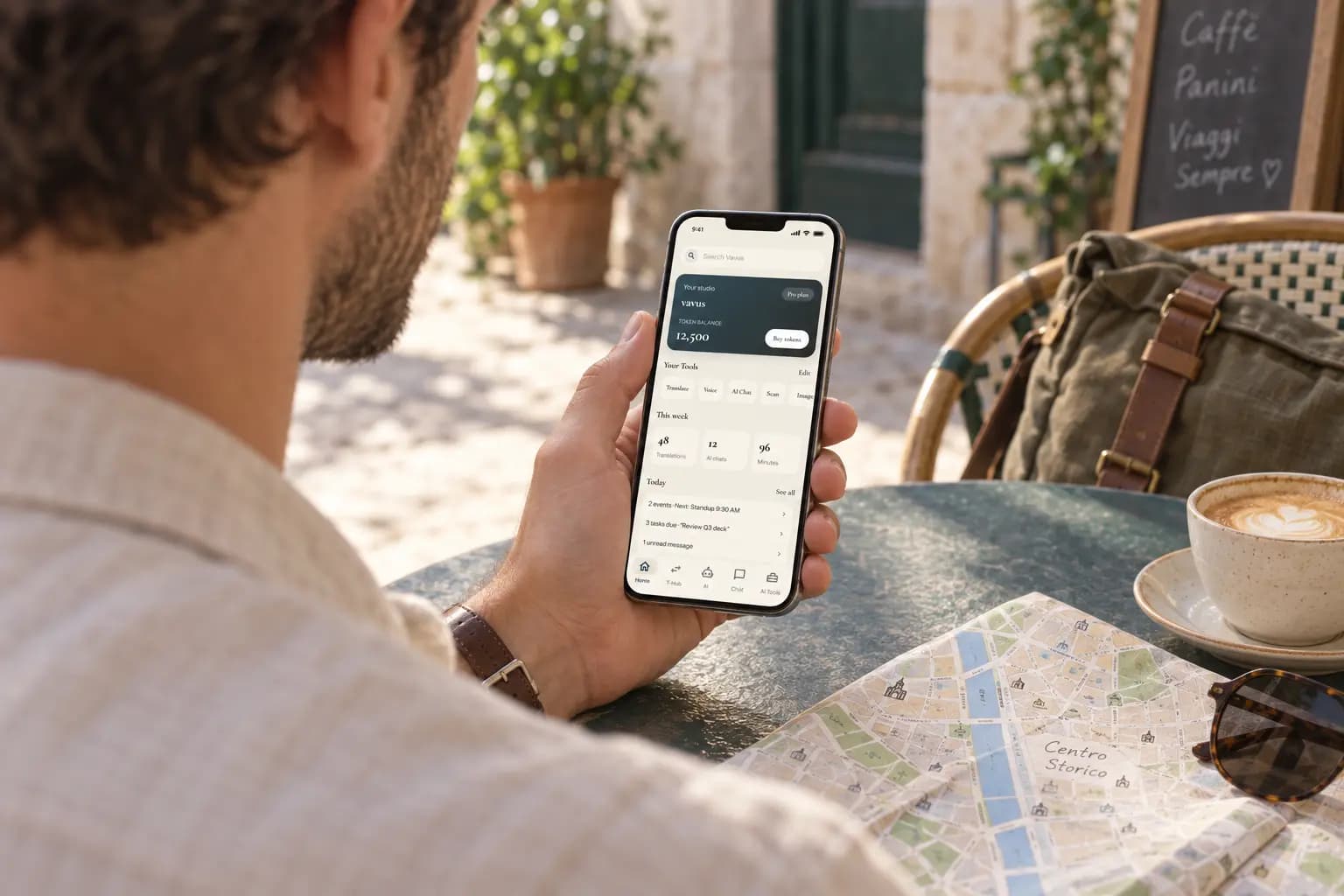 A traveller checking Vavus tools on a phone held at a cafe table beside a city map